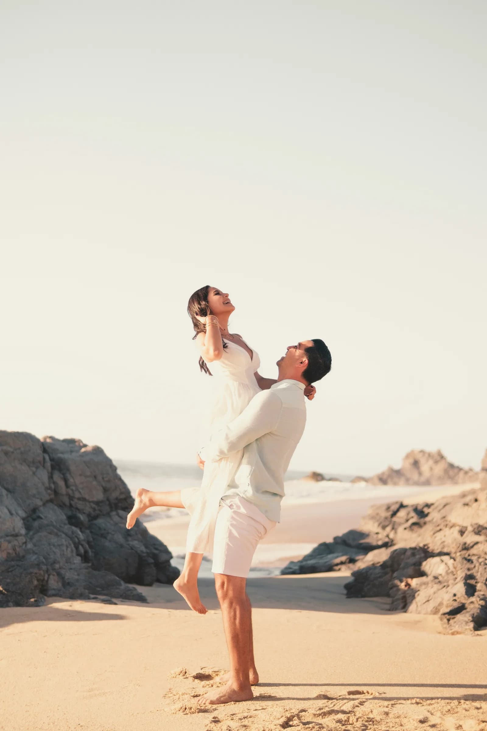Couple walking the beach in soft sunlight
